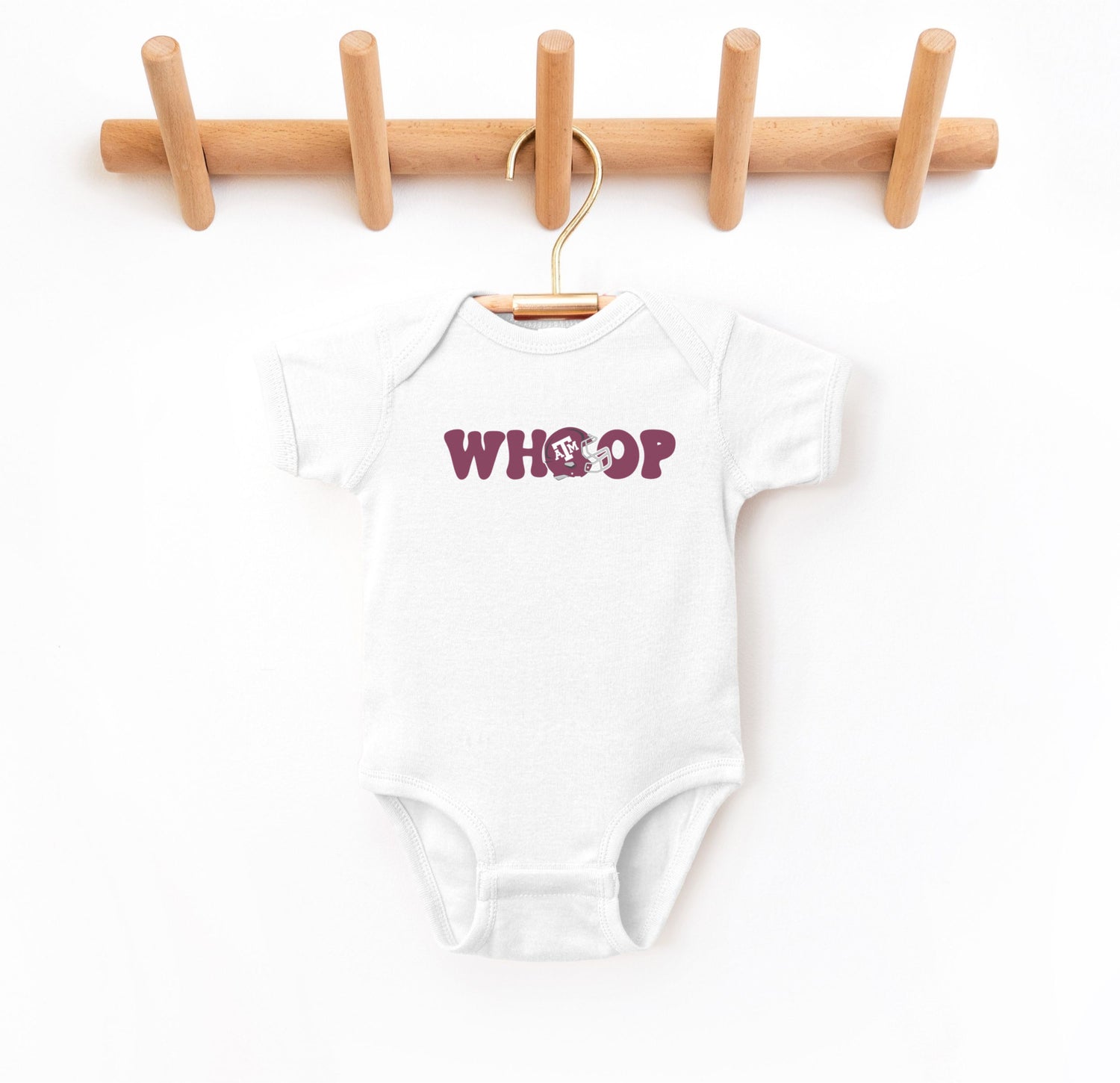The White Infant Unisex Texas A&M Retro Whoop Bodysuit lays flat on a white background. The ﻿Texas A&M Retro Whoop﻿ graphic is in bold Maroon in a Vintage style.