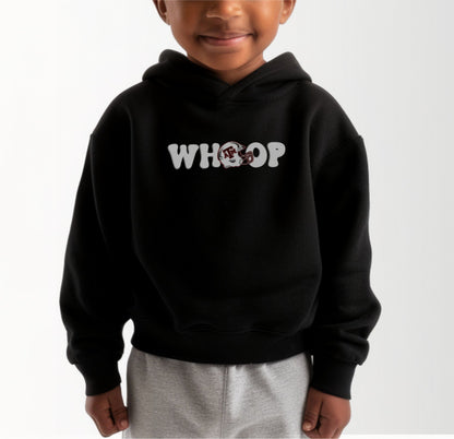 A model wears the Black Toddler Unisex Texas A&M Retro Whoop Hooded Sweatshirt.  The ﻿Texas A&M Retro Whoop﻿ graphic is in bold White in a Vintage style.