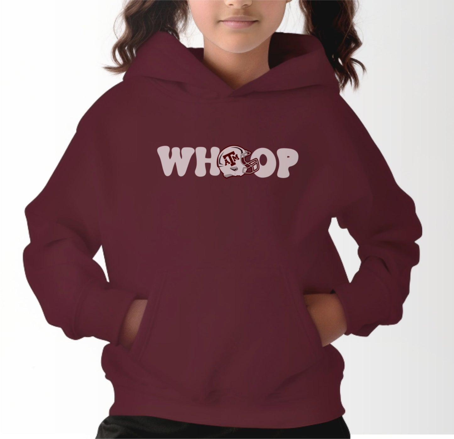 A model wears the Maroon Youth Unisex Texas A&M Retro Whoop Hooded Sweatshirt.  The ﻿Texas A&M Retro Whoop﻿ graphic is in bold White in a Vintage style.