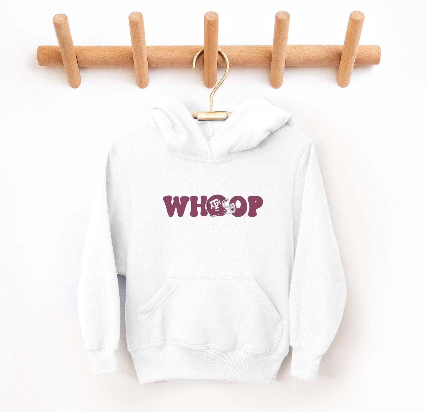 The White Youth Unisex Texas A&M Retro Whoop Hooded Sweatshirt lays flat on a white background. The ﻿Texas A&M Retro Whoop﻿ graphic is in bold Maroon in a Vintage style.