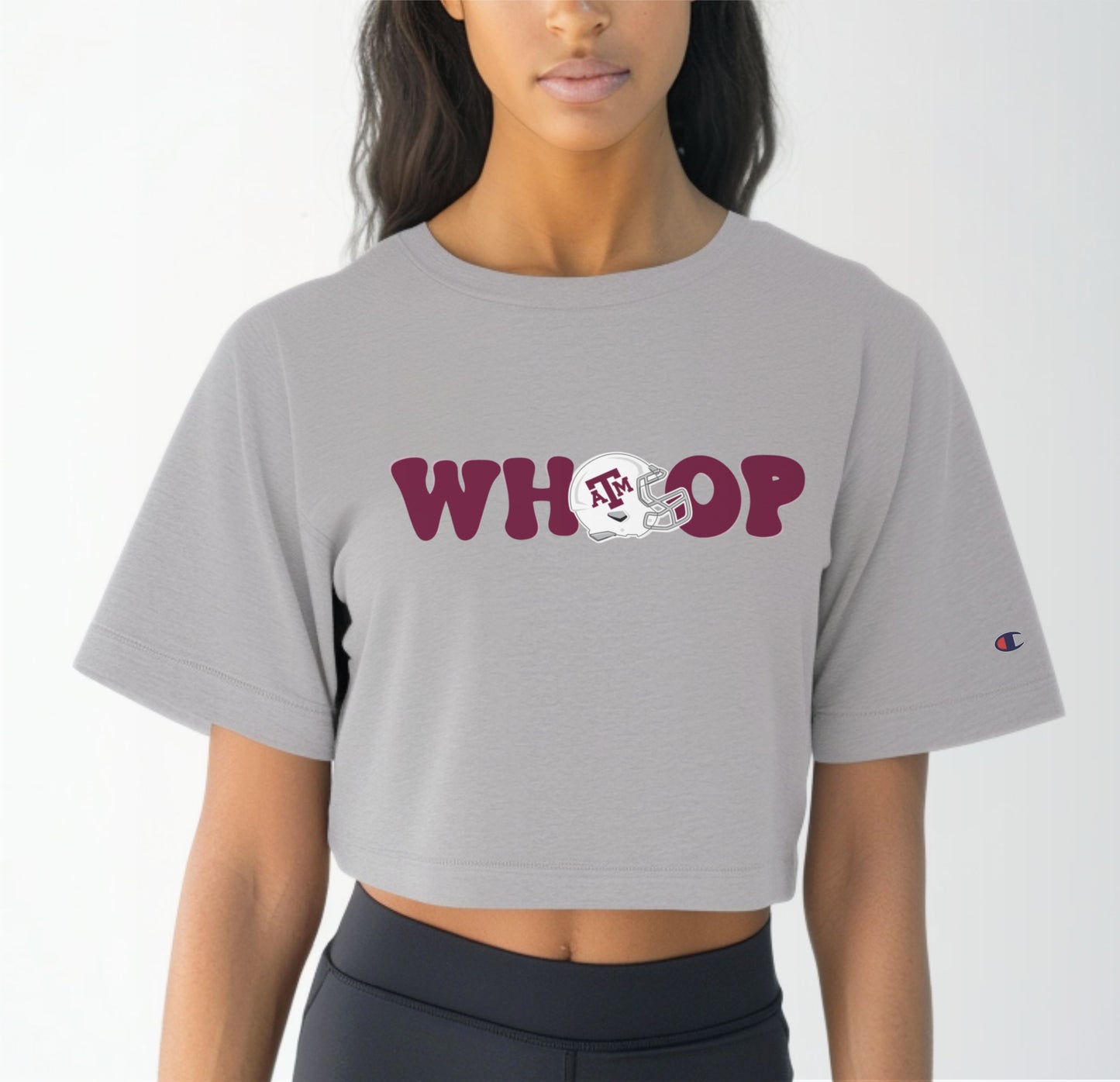 A model wears the Oxford Grey Adult Womens Texas A&M Retro Whoop Crop Top.  The ﻿Texas A&M Retro Whoop﻿ graphic is in bold Maroon in a Vintage style.