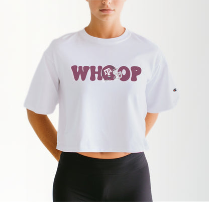 A model wears the White Adult Womens Texas A&M Retro Whoop Crop Top.  The ﻿Texas A&M Retro Whoop﻿ graphic is in bold Maroon in a Vintage style.