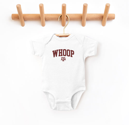 The White Infant Unisex Texas A&M Whoop Collegiate Bodysuit lays flat on a white background. The ﻿Texas A&M Whoop Collegiate﻿ graphic is in bold Maroon in a Varsity style.