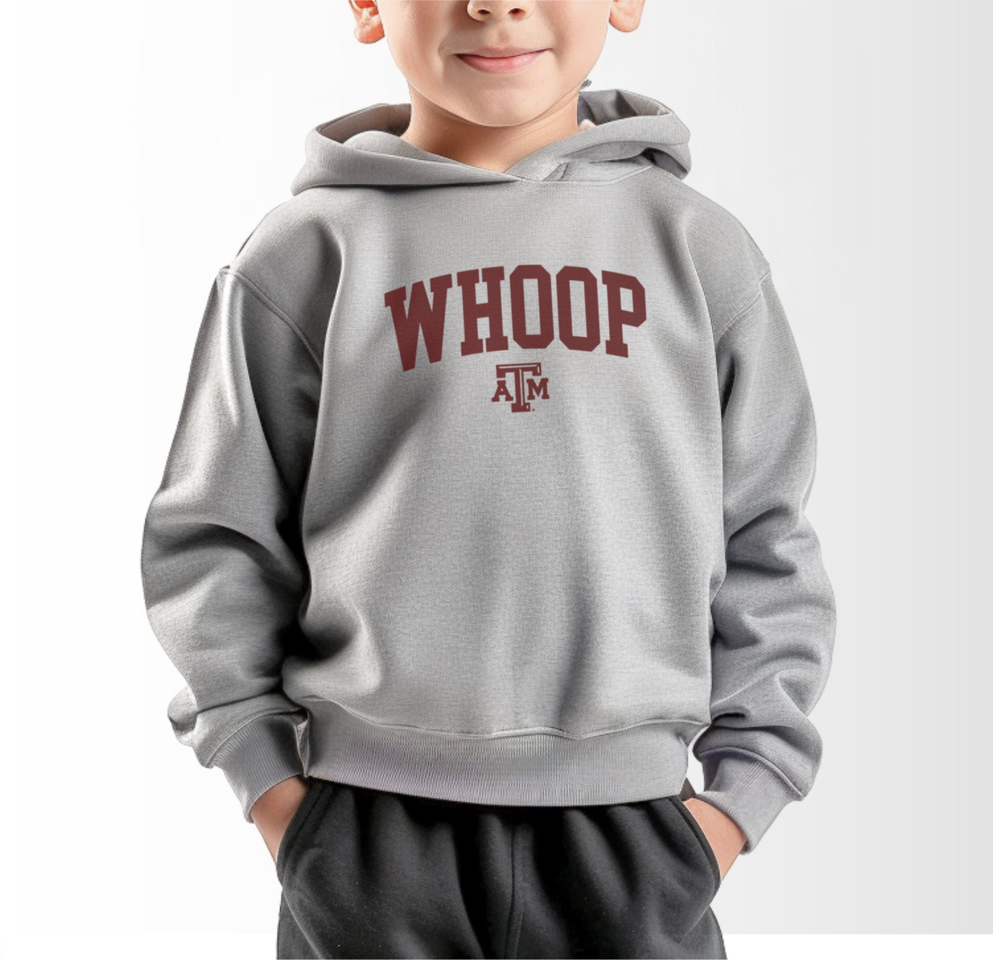 A model wears the Heather Grey Toddler Unisex Texas A&M Whoop Collegiate Hooded Sweatshirt.  The ﻿Texas A&M Whoop Collegiate﻿ graphic is in bold Maroon in a Varsity style.