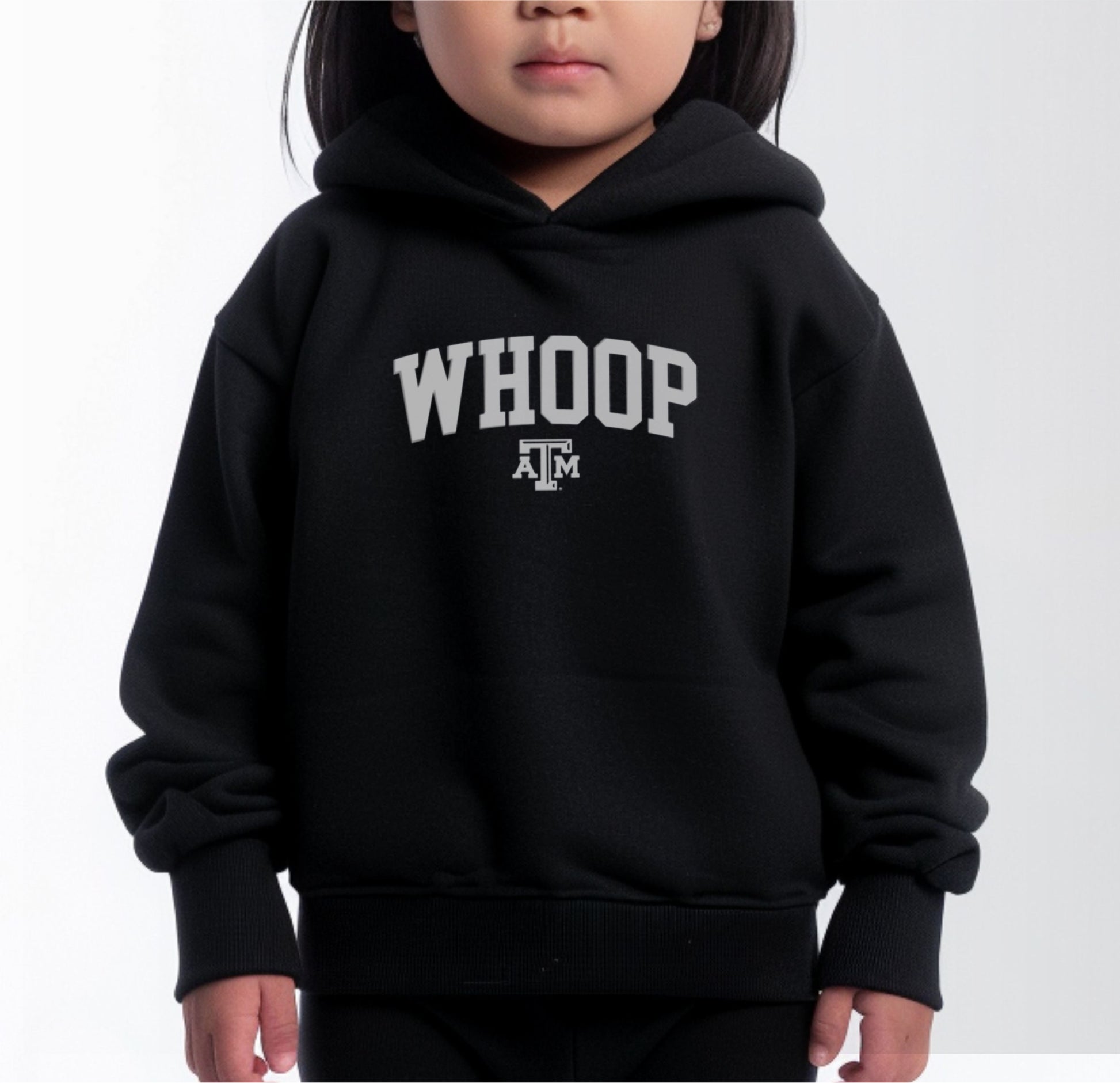 A model wears the Black Toddler Unisex Texas A&M Whoop Collegiate Hooded Sweatshirt.  The ﻿Texas A&M Whoop Collegiate﻿ graphic is in bold White in a Varsity style.