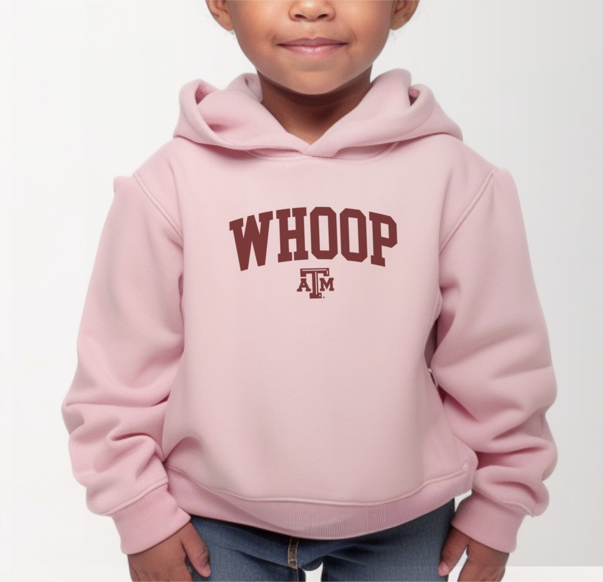 A model wears the Pink Toddler Unisex Texas A&M Whoop Collegiate Hooded Sweatshirt.  The ﻿Texas A&M Whoop Collegiate﻿ graphic is in bold White in a Varsity style.