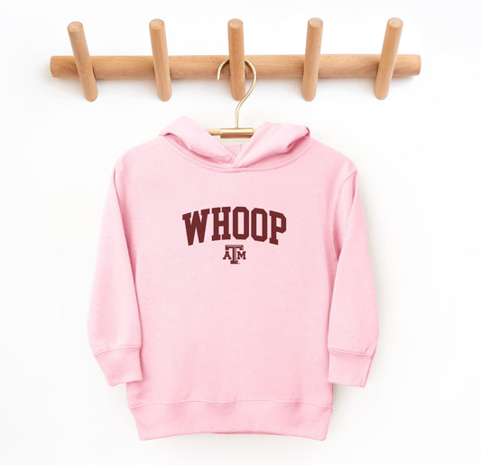 The Pink Toddler Unisex Texas A&M Whoop Collegiate Hooded Sweatshirt lays flat on a white background. The ﻿Texas A&M Whoop Collegiate﻿ graphic is in bold White in a Varsity style.