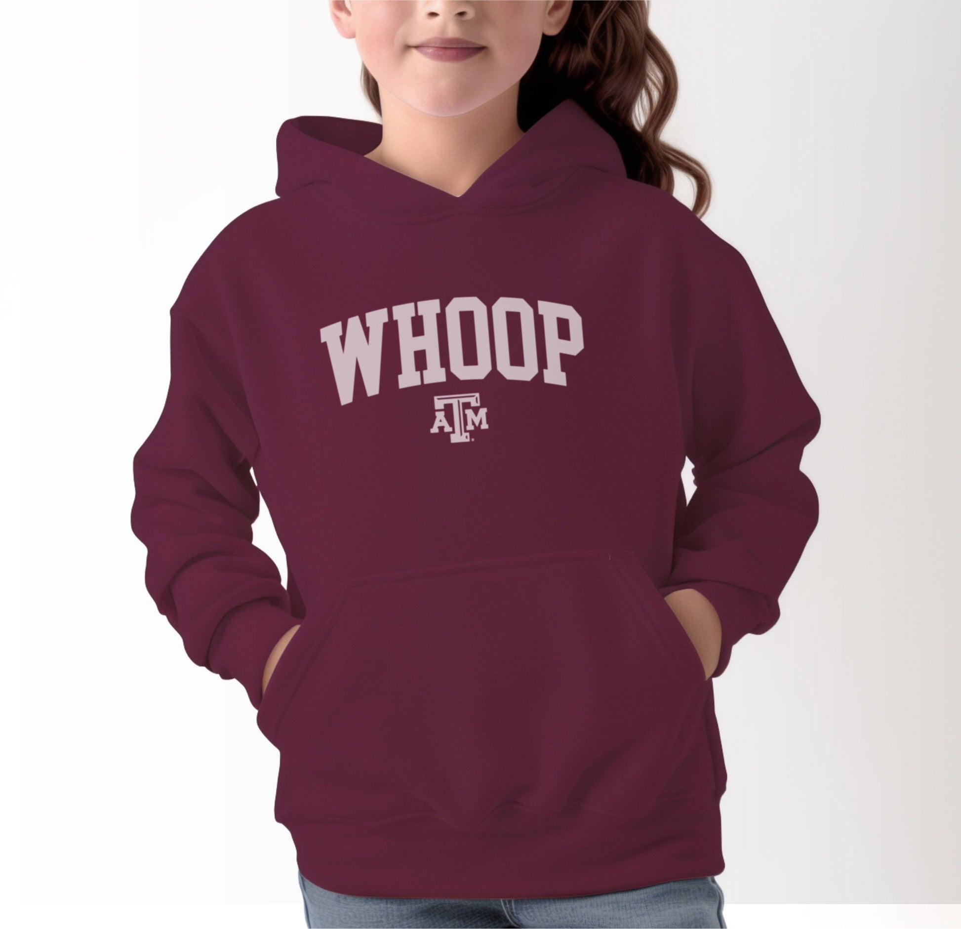 A model wears the Maroon Youth Unisex Texas A&M Whoop Collegiate Hooded Sweatshirt.  The ﻿Texas A&M Whoop Collegiate﻿ graphic is in bold White in a Varsity style.