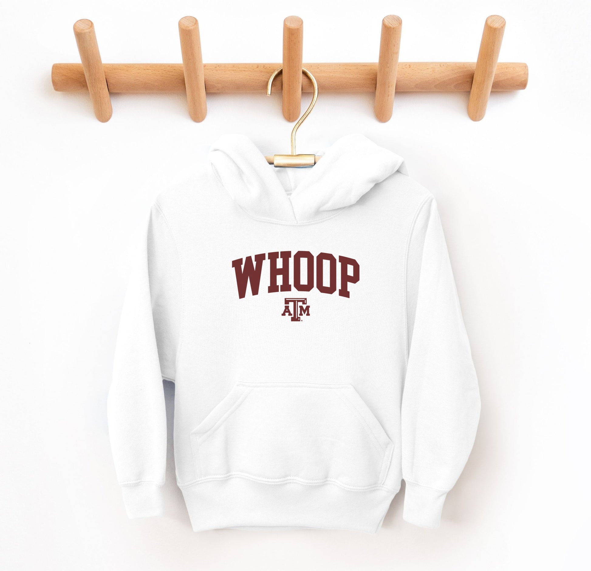 The White Youth Unisex Texas A&M Whoop Collegiate Hooded Sweatshirt lays flat on a white background. The ﻿Texas A&M Whoop Collegiate﻿ graphic is in bold Maroon in a Varsity style.