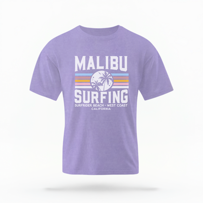 The Violet Adult Unisex Malibu California Surfing Comfort Colors T-shirt lays flat on a white background. The ﻿Malibu California Surfing﻿ graphic is in bold Lifestyle in a Multicolor style.