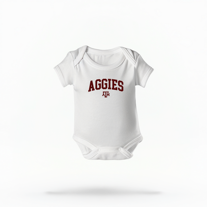 The White Infant Unisex Texas A&M Aggies Collegiate Bodysuit lays flat on a white background. The ﻿Texas A&M Aggies Collegiate﻿ graphic is in bold Maroon in a Varsity style.