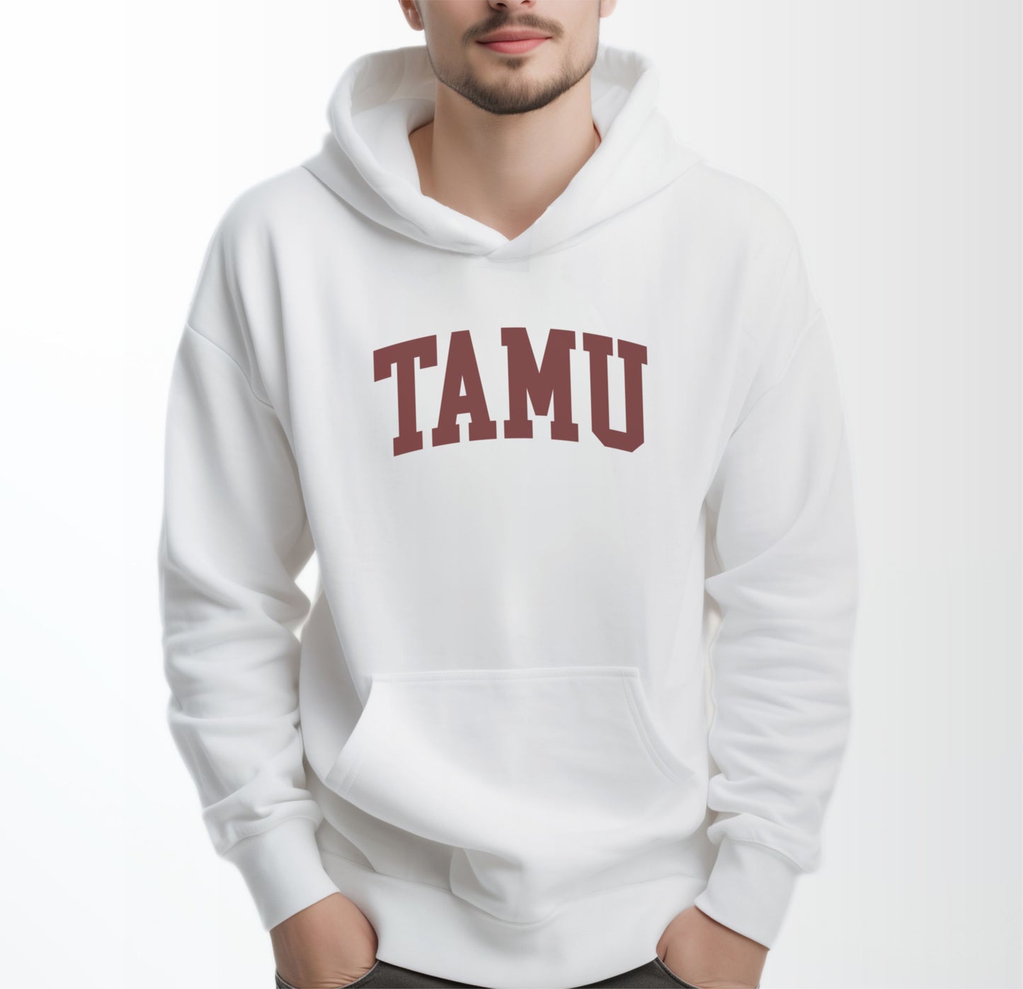 A model wears the White Adult Unisex Texas A&M TAMU Hooded Sweatshirt.  The ﻿Texas A&M TAMU﻿ graphic is in bold Maroon in a Collegiate style.