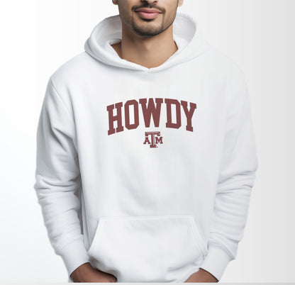 A model wears the White Adult Unisex Texas A&M Howdy Varsity Hooded Sweatshirt.  The ﻿Texas A&M Howdy Varsity﻿ graphic is in bold Maroon in a Collegiate style.