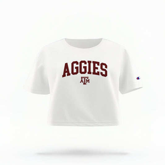 The White Adult Womens Texas A&M Aggies Collegiate Crop Top lays flat on a white background. The ﻿Texas A&M Aggies Collegiate﻿ graphic is in bold Maroon in a Varsity style.