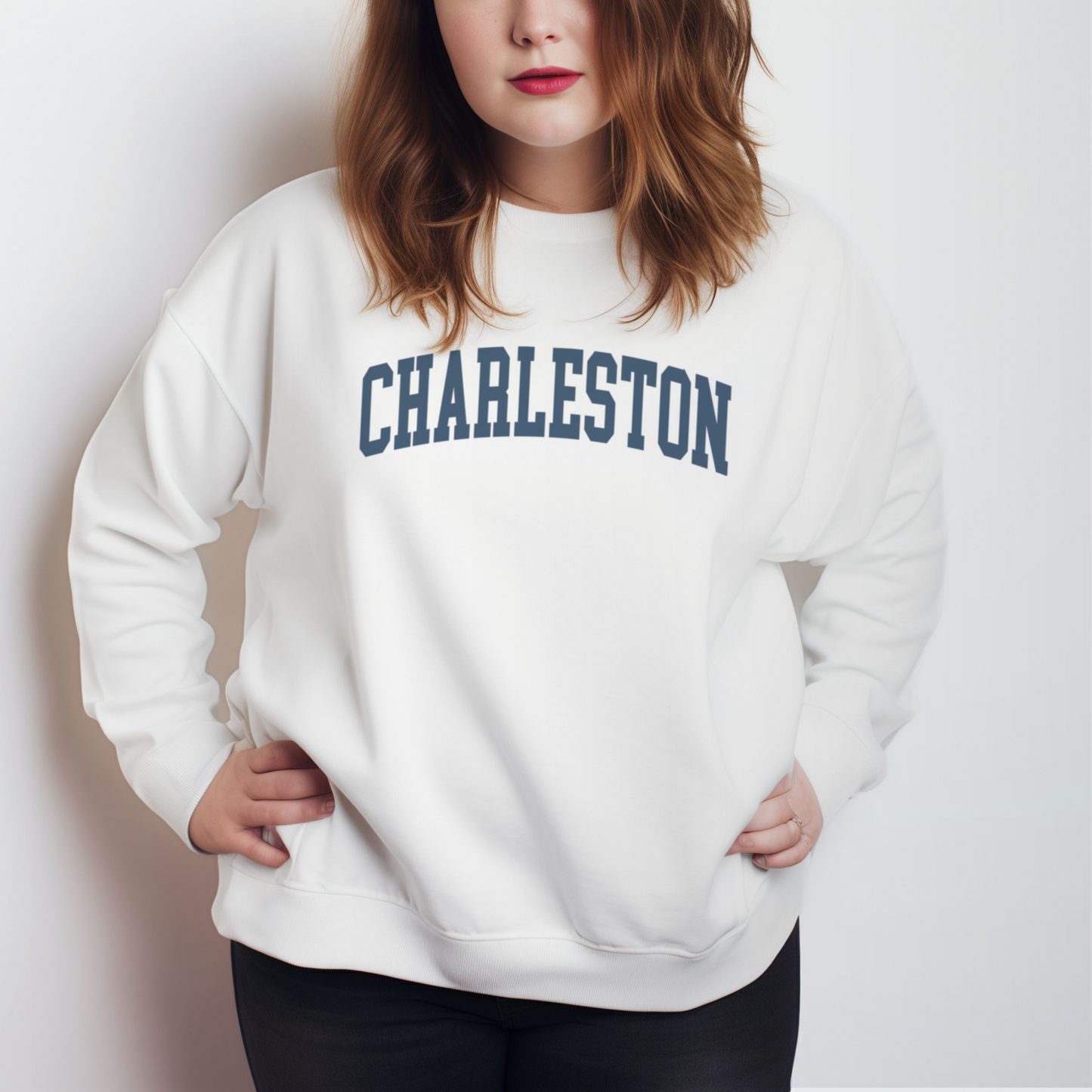 A model wears the White Adult Unisex Charleston SC Collegiate Crewneck Sweatshirt.  The ﻿Charleston SC Collegiate﻿ graphic is in bold Navy in a Varsity style.