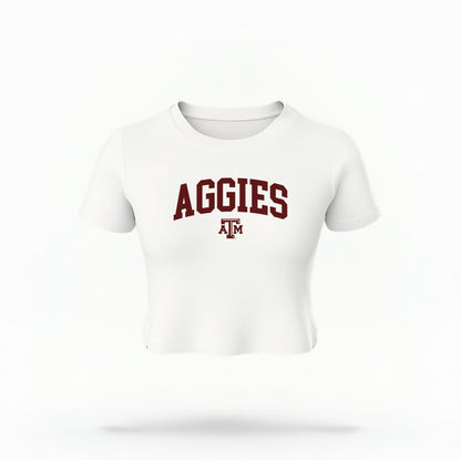 The White Texas A&M Aggies Collegiate Crop Top lays flat on a white background. The ﻿Texas A&M Aggies Collegiate﻿ graphic is in bold Maroon in a Varsity style.