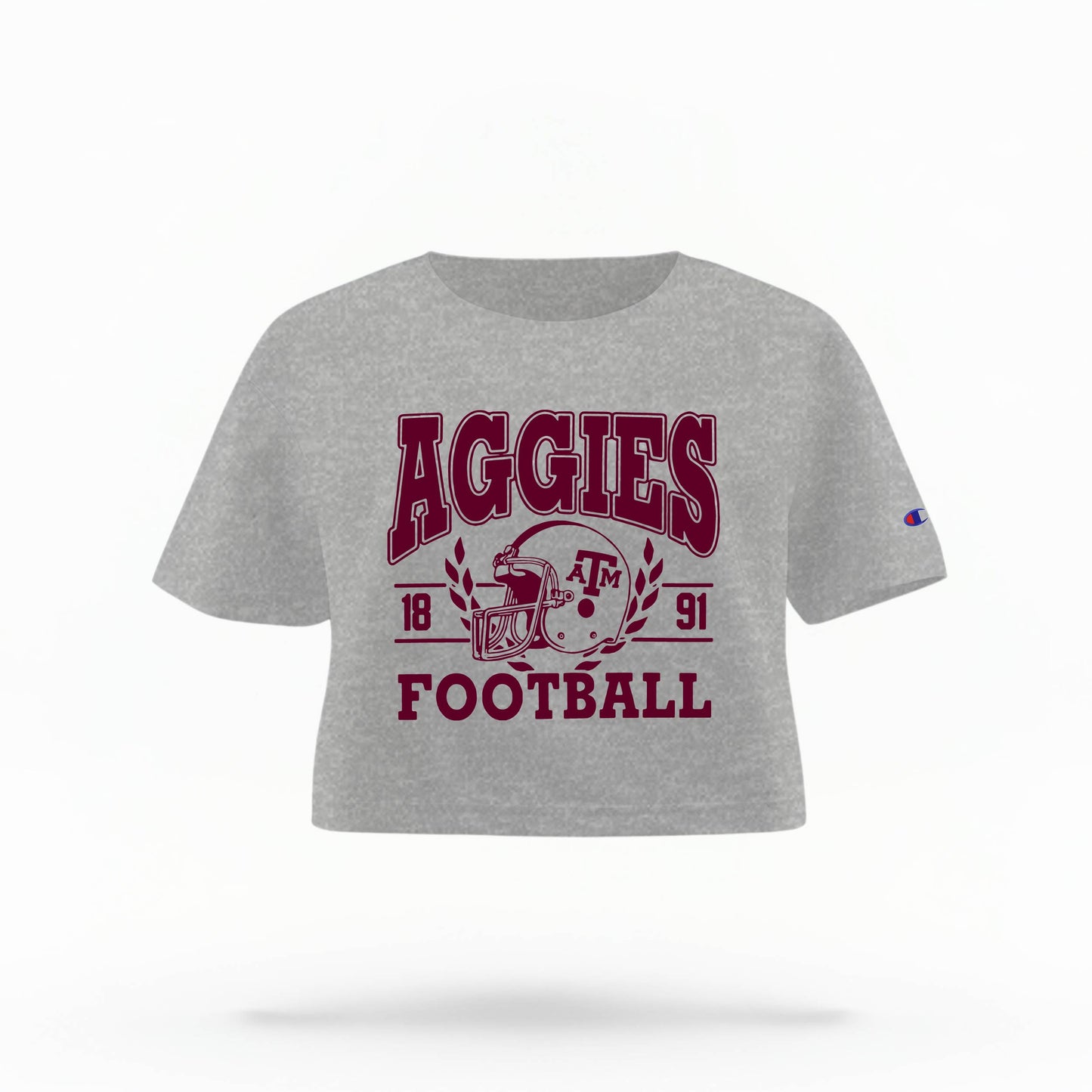 Texas A&M Aggies Women's Crop Top in grey and maroon, featuring the "Aggies" logo and a football helmet graphic.