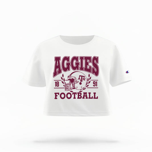 Texas A&M Aggies Women's Crop Top in maroon and white, featuring the "Aggies" logo and a football helmet graphic.