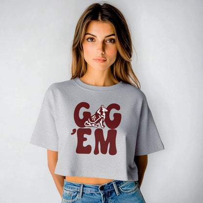 A model wears the Oxford Grey Adult Womens Texas A&M Gig 'Em Retro Reveille Crop Top.  The ﻿Texas A&M Gig 'Em Retro Reveille﻿ graphic is in bold Maroon in a Groovy Vintage style.