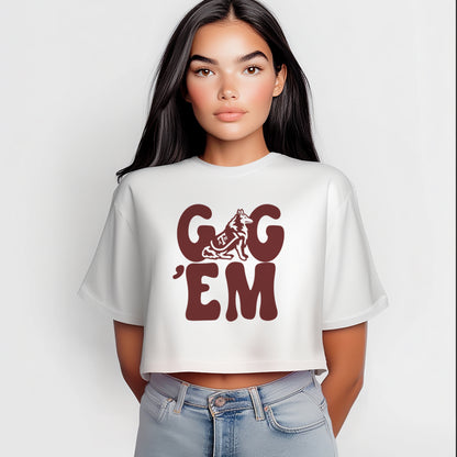 A model wears the WhiteAdult Womens Texas A&M Gig 'Em Retro Reveille Crop Top.  The ﻿Texas A&M Gig 'Em Retro Reveille﻿ graphic is in bold Maroon in a Groovy Vintage style.