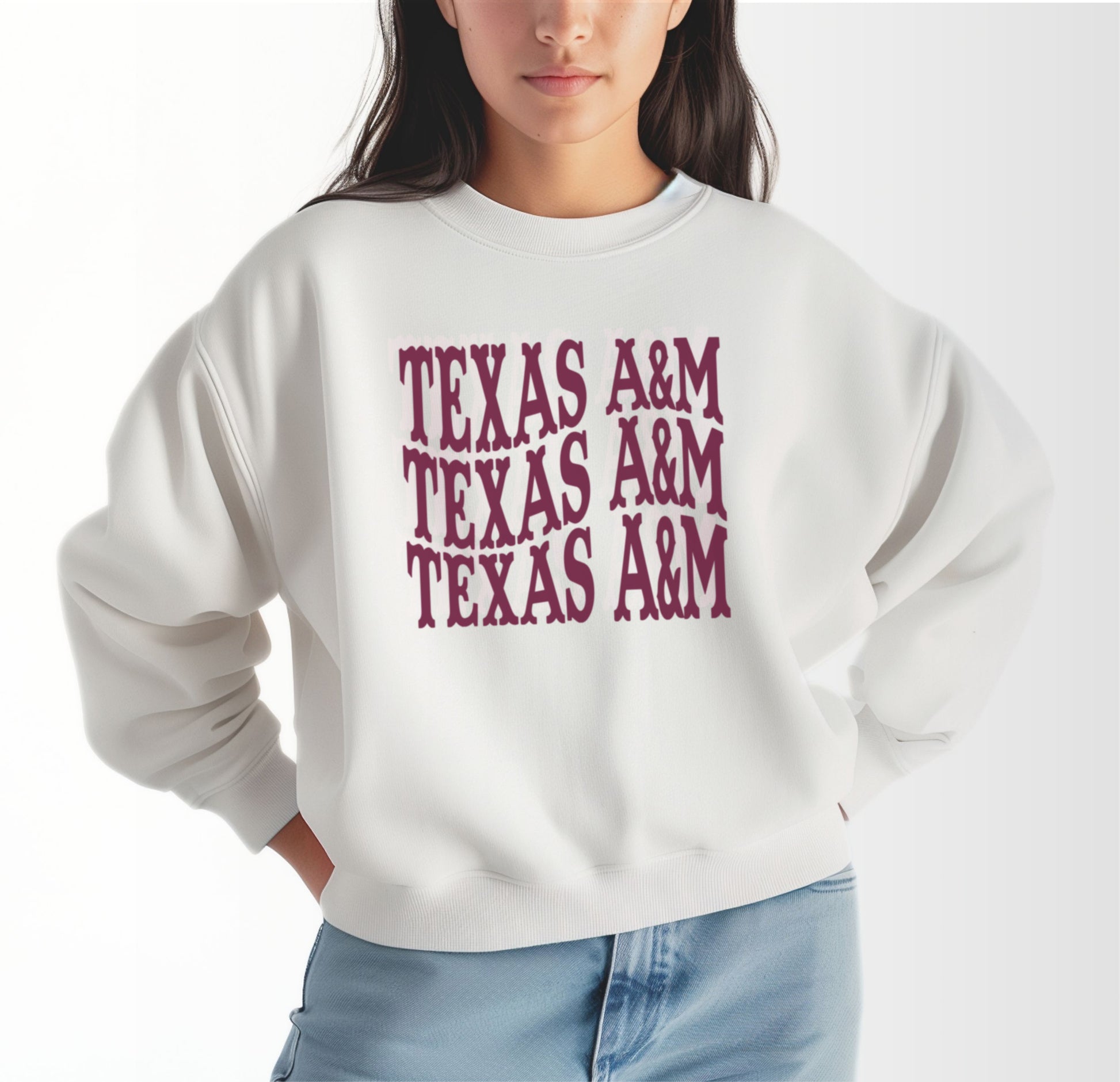 A model wears the White Adult Unisex Texas A&M Western Crewneck Sweatshirt.  The ﻿Texas A&M Western﻿ graphic is in bold Maroon in a Western style.