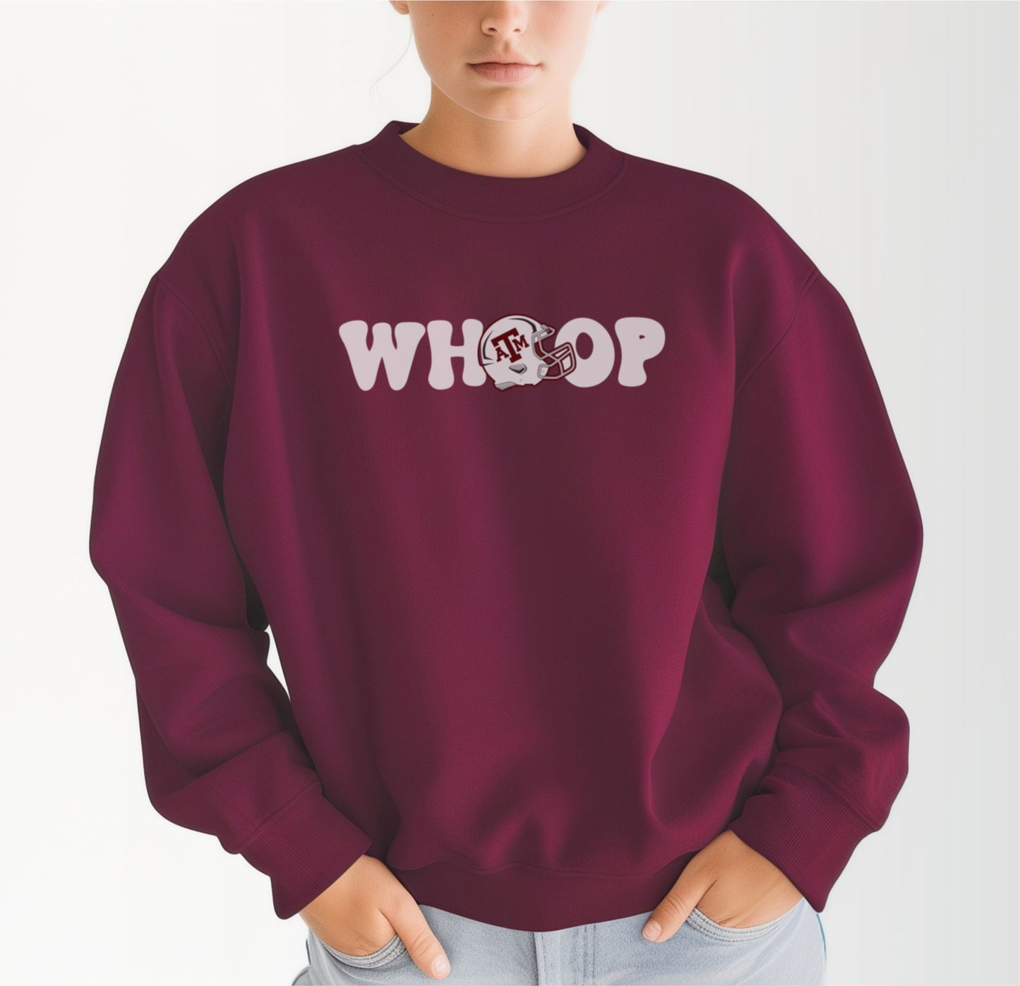 A model wears the Maroon Adult Unisex Texas A&M Retro Whoop Crewneck Sweatshirt.  The ﻿Texas A&M Retro Whoop﻿ graphic is in bold White in a Vintage style.