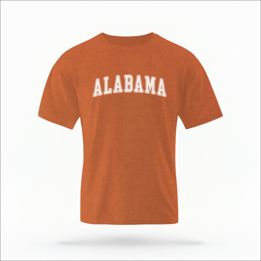 The Yam Unisex Alabama Varsity Comfort Colors T-shirt lays flat on a white background. The Alabama graphic is in bold white in a varsity offset style.
