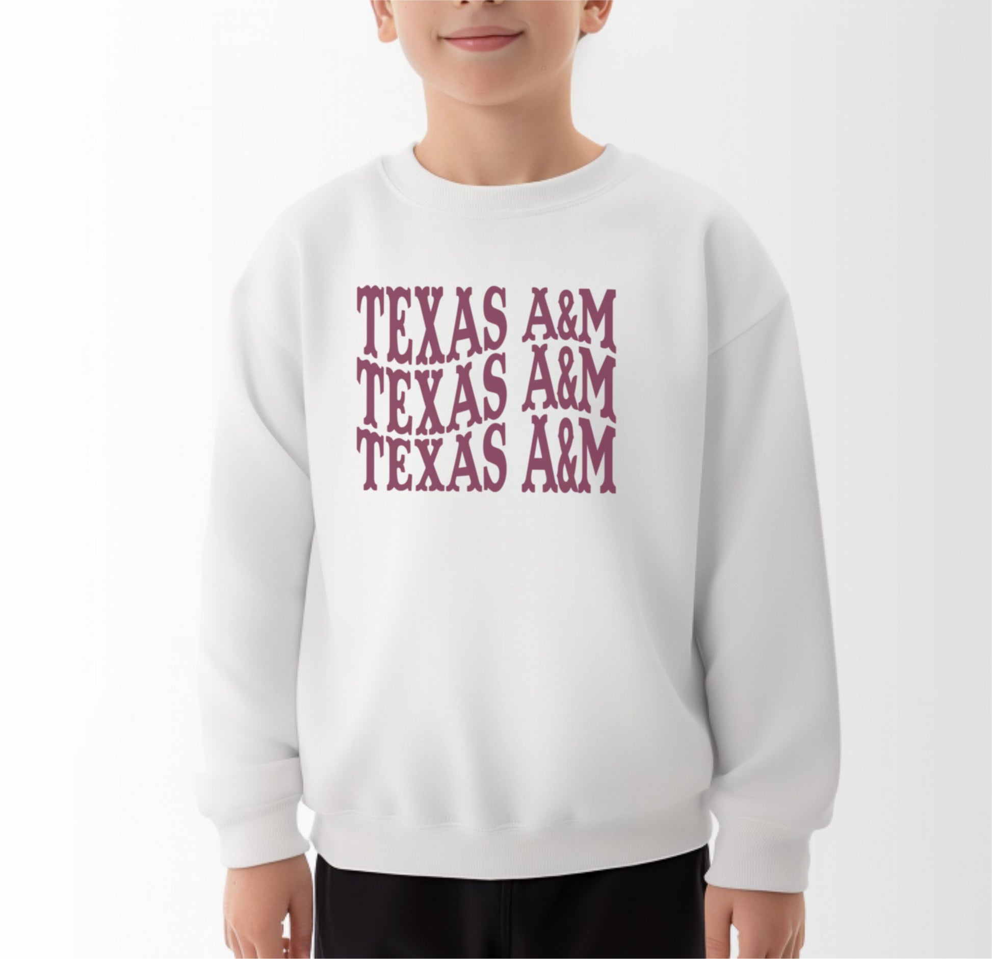 A model wears the White Youth Unisex Texas A&M Western Crewneck Sweatshirt.  The ﻿Texas A&M Western﻿ graphic is in bold Maroon in a Western style.