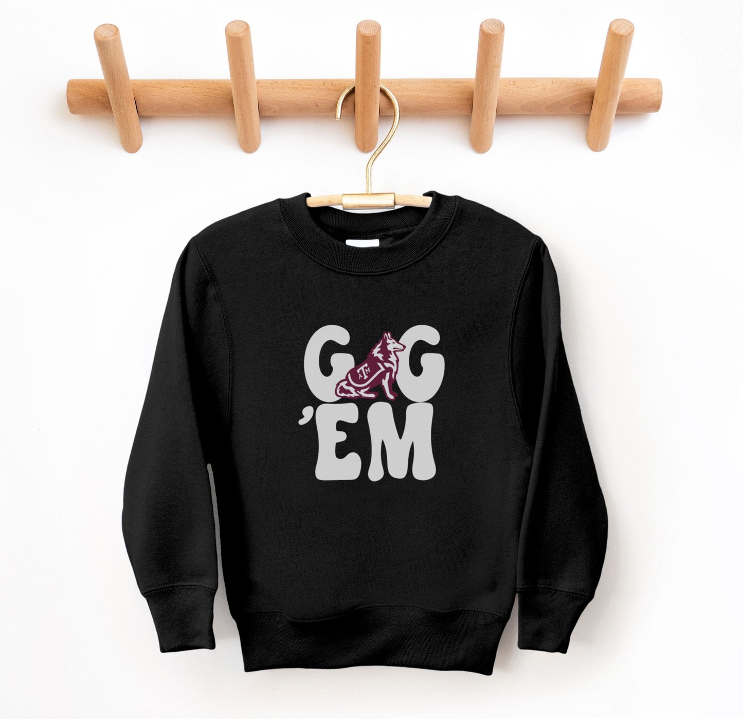 The Black Youth Unisex Texas A&M Gig 'Em Retro Reveille Crewneck Sweatshirt lays flat on a white background. The ﻿Texas A&M Gig 'Em Retro Reveille﻿ graphic is in bold White in a Groovy Vintage style.