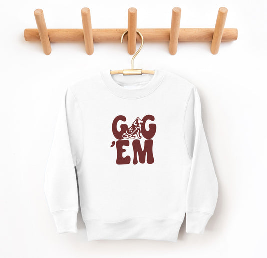 The White Youth Unisex Texas A&M Gig 'Em Retro Reveille Crewneck Sweatshirt lays flat on a white background. The ﻿Texas A&M Gig 'Em Retro Reveille﻿ graphic is in bold Maroon in a Groovy Vintage style.