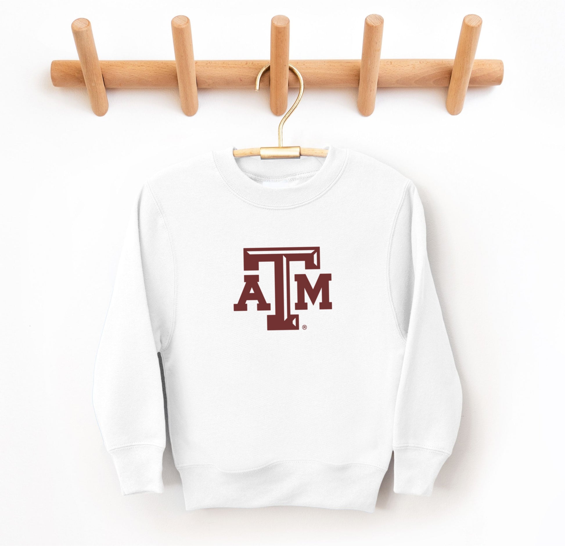 The White Youth Unisex Texas A&M Logo Crewneck Sweatshirt lays flat on a white background. The ﻿Texas A&M Logo﻿ graphic is in bold Maroon in a Varsity style.