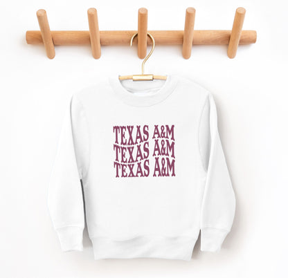 The White Youth Unisex Texas A&M Western Crewneck Sweatshirt lays flat on a white background. The ﻿Texas A&M Western﻿ graphic is in bold Maroon in a Western style.