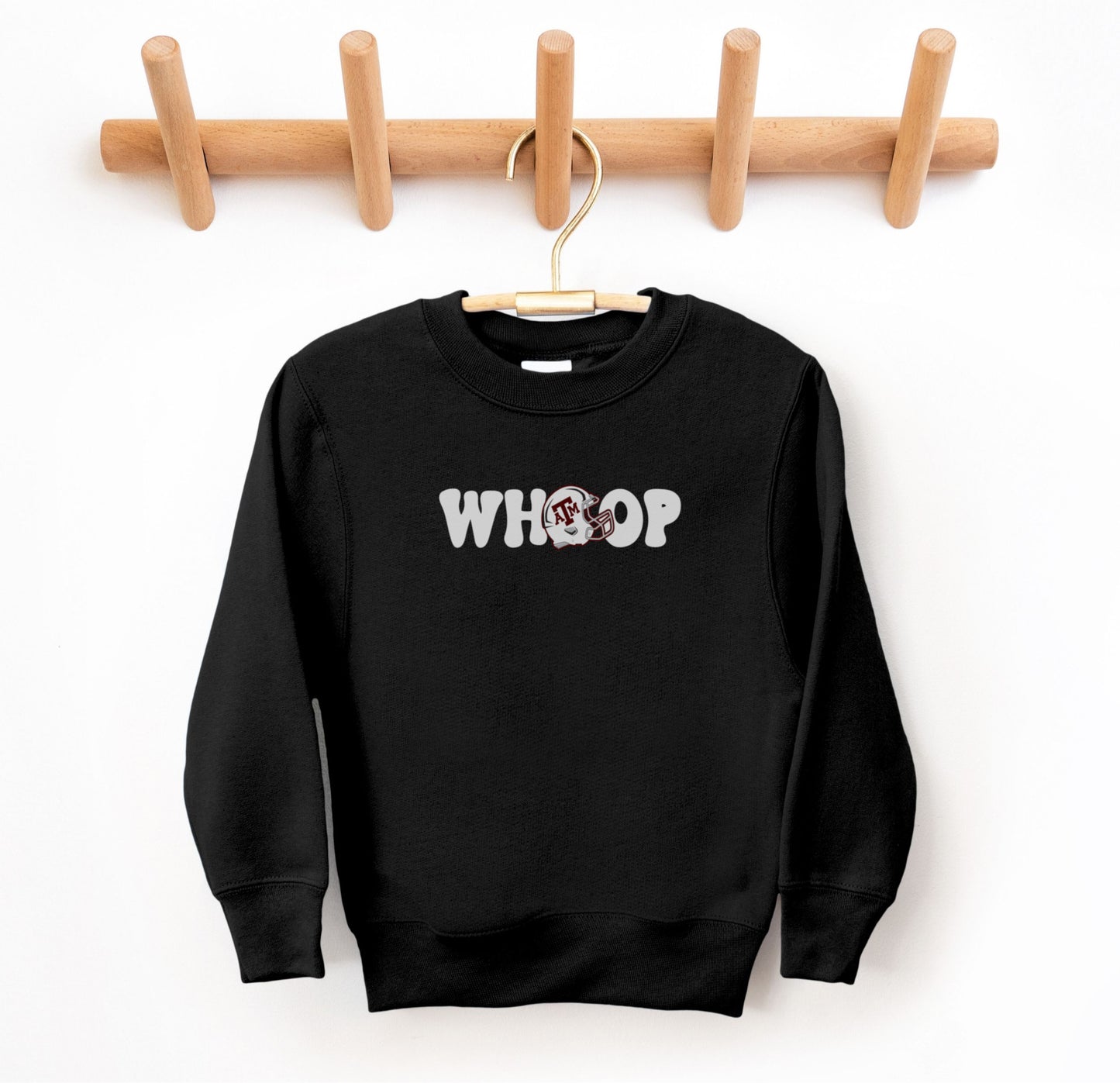 The Black Youth Unisex Texas A&M Retro Whoop Crewneck Sweatshirt lays flat on a white background. The ﻿Texas A&M Retro Whoop﻿ graphic is in bold White in a Vintage style.