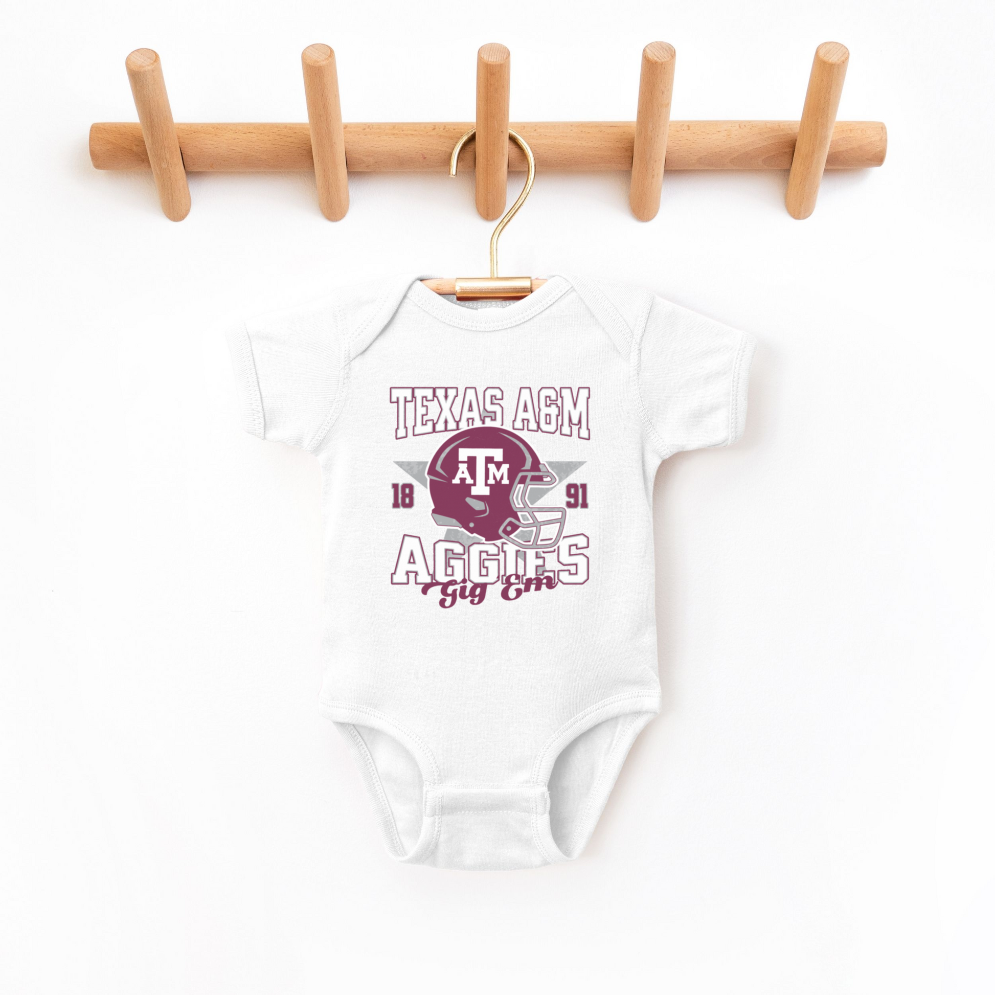 The White Texas A&M Aggies Football Bodysuit lays flat on a white background. The ﻿Texas A&M Aggies Football﻿ graphic is in bold Multicolor in a Varsity style.