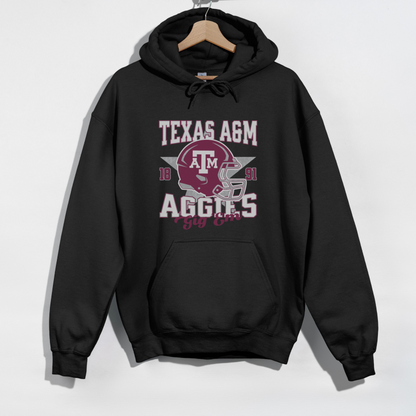 The Black Texas A&M Aggies Football Hoodie Sweatshirt lays flat on a white background. The ﻿Texas A&M Aggies Football﻿ graphic is in bold Unisex in a Varsity style.