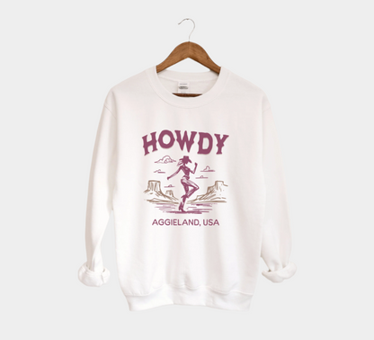 The White Howdy from Aggieland Western Crewneck Sweatshirt lays flat on a white background. The ﻿Howdy from Aggieland Western﻿ graphic is in bold Unisex in a Western style.