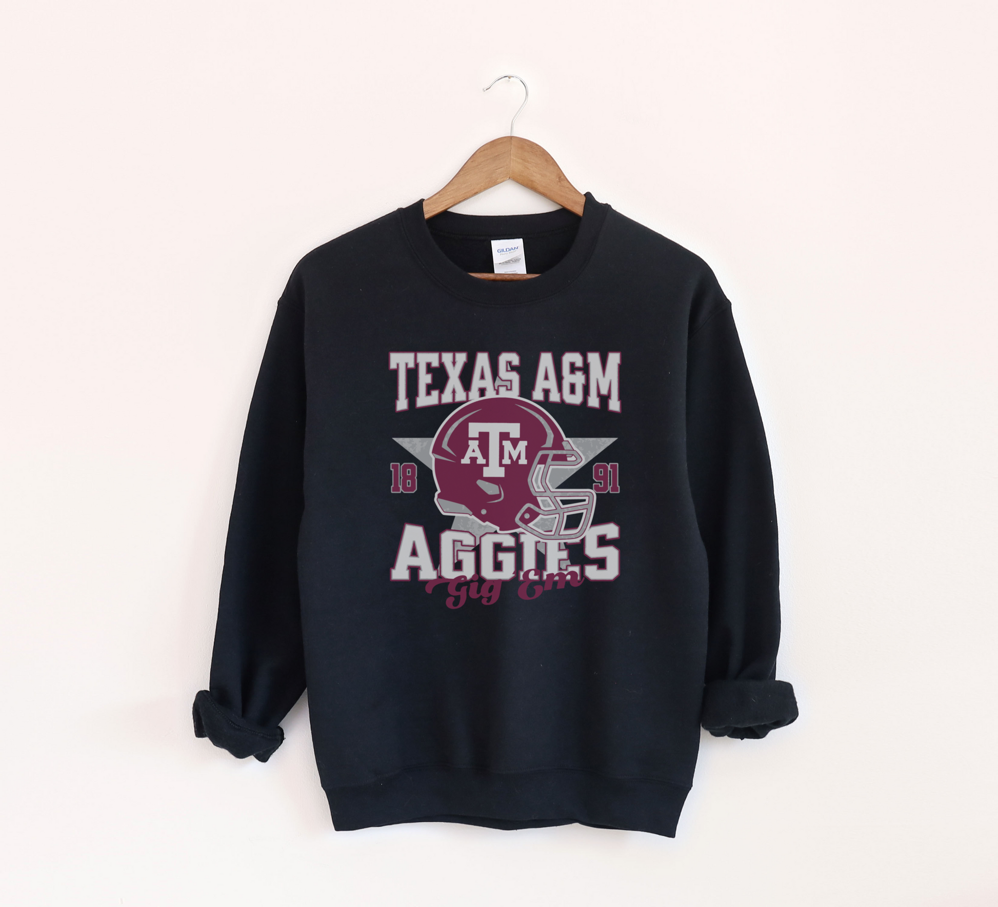 The Black Texas A&M Aggies Football Crewneck Sweatshirt lays flat on a white background. The ﻿Texas A&M Aggies Football﻿ graphic is in bold Unisex in a Varsity style.