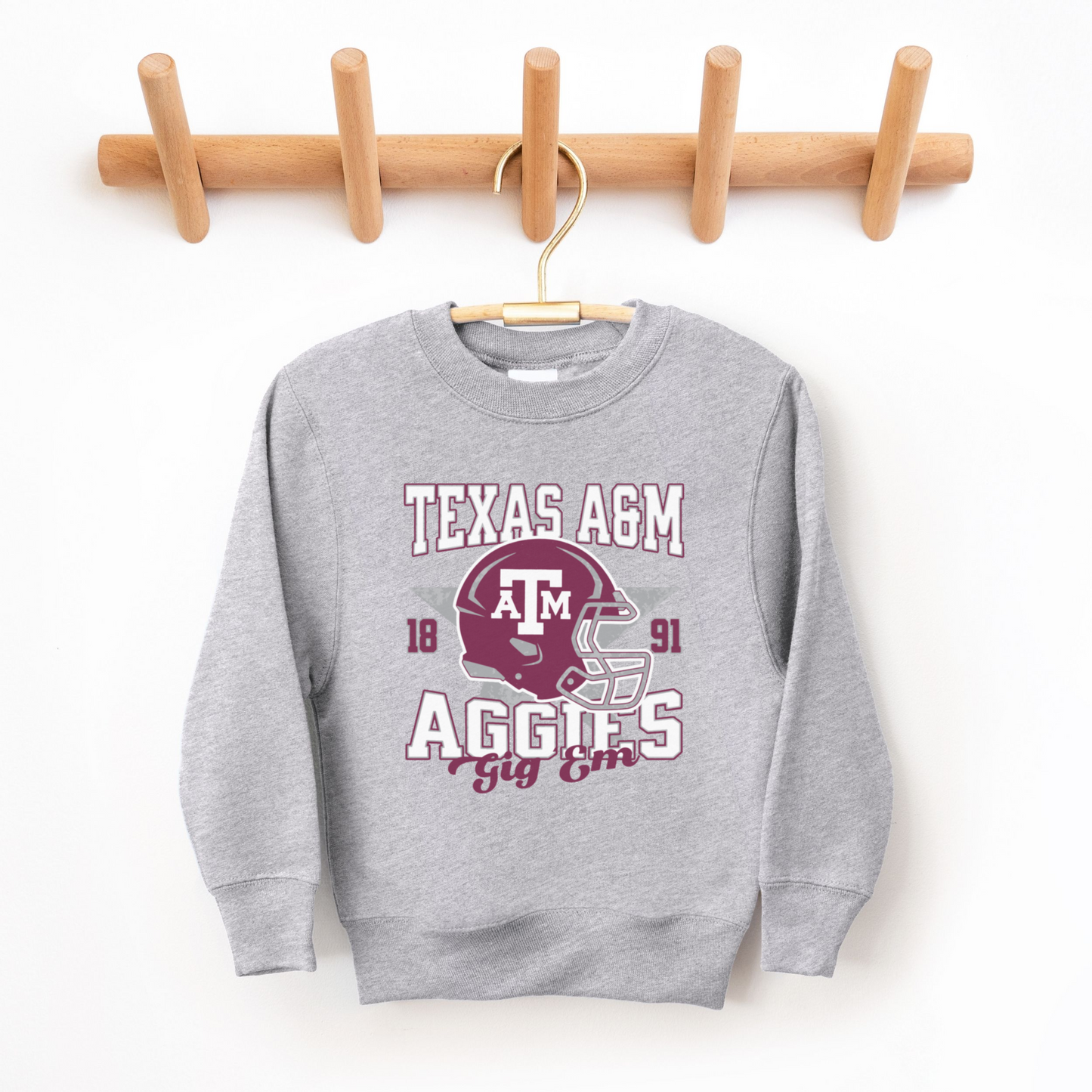 The Sport Grey Texas A&M Aggies Football Crewneck Sweatshirt lays flat on a white background. The ﻿Texas A&M Aggies Football﻿ graphic is in bold Multicolor in a Varsity style.