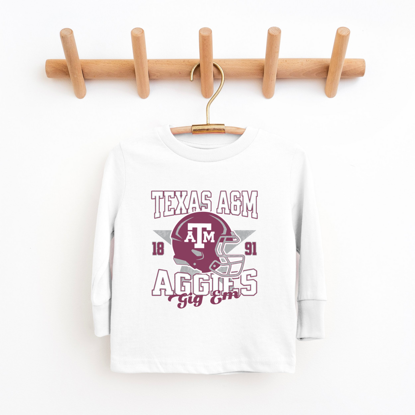 The White Texas A&M Aggies Football Long Sleeve T-shirt lays flat on a white background. The ﻿Texas A&M Aggies Football﻿ graphic is in bold Multicolor in a Varsity style.